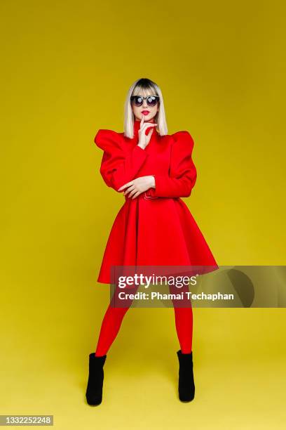 fashionable woman dresses in red - lady studio sonnenbrille stock-fotos und bilder