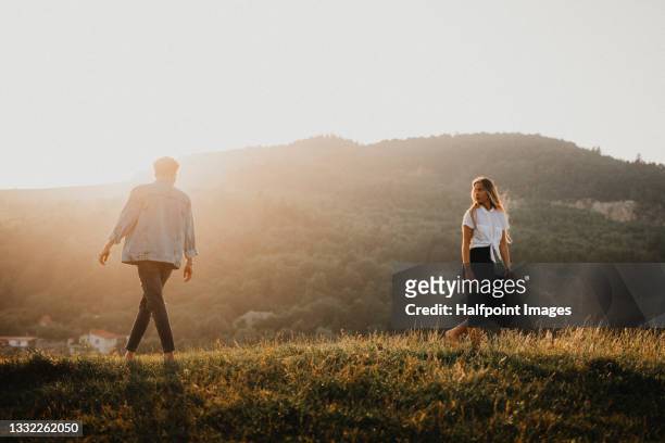portrait of young couple on a walk outdoors in nature, walking away from each other. - relationship difficulties stock pictures, royalty-free photos & images