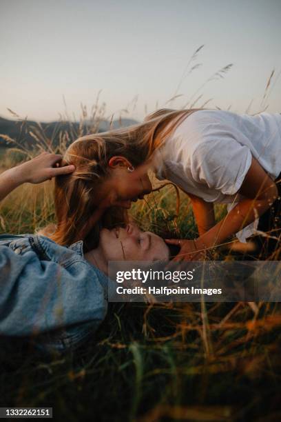 portrait of young couple on a walk outdoors in nature, lying on grass. - young couple enjoying a walk through grassland stock pictures, royalty-free photos & images