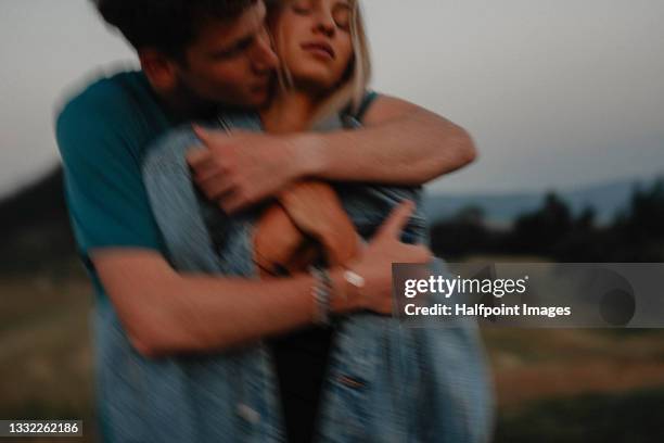 blurred portrait of young couple on a walk outdoors in nature, hugging. - young couple enjoying a walk through grassland stock pictures, royalty-free photos & images