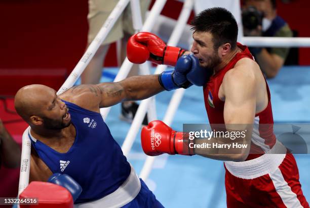 Bakhodir Jalolov of Team Uzbekistan exchanges punches with Frazer Clarke of Team Great Britain during the Men's Super Heavy semi final on day twelve...