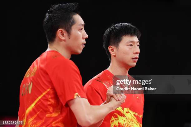 Xu Xin and Ma Long of Team China shake hands during their Men's Team Semifinals table tennis match on day twelve of the Tokyo 2020 Olympic Games at...