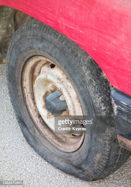 deflated vehicle tire - puncture - beat up car stockfoto's en -beelden