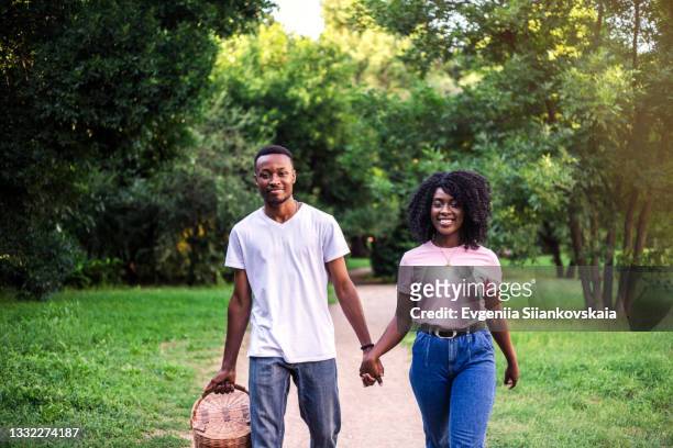 young black couple walking outdoors at summer. - woman look straight black shirt stock pictures, royalty-free photos & images