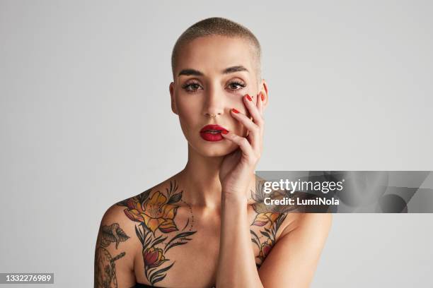 studio portrait of a beautiful young woman posing against a grey background - androgynous 個照片及圖片檔