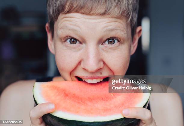 young woman wants to eat a piece of melon - zähne stock-fotos und bilder