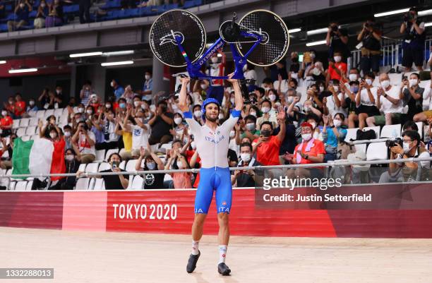 Filippo Ganna of Team Italy lifts his bike to celebrates winning a gold medal after setting a new World record during the Men's team pursuit finals,...
