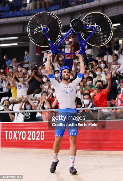 Filippo Ganna of Team Italy lifts his bike to celebrates winning a gold medal after setting a new World record during the Men's team pursuit finals,...