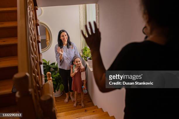 mother and daughter waving back to a nanny, before they leave for the school - nanny stock pictures, royalty-free photos & images