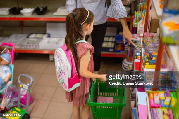 school girl with her mother choosing between big variety of notebooks for new school year - office supply 個照片及圖片檔