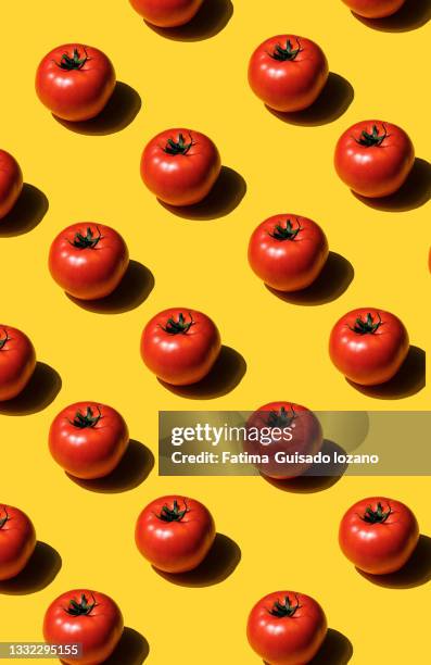 pattern of sliced tomatoes on yellow background - tomaten stockfoto's en -beelden