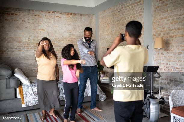 teenager boy filming family dancing at home - dance challenge stock pictures, royalty-free photos & images