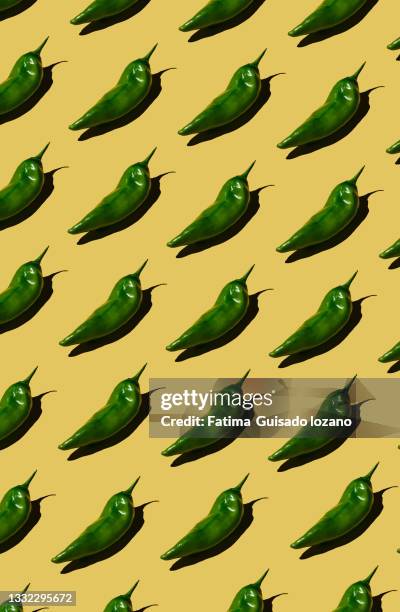 pattern of green peppers on yellow background - fondo amarillo stock pictures, royalty-free photos & images