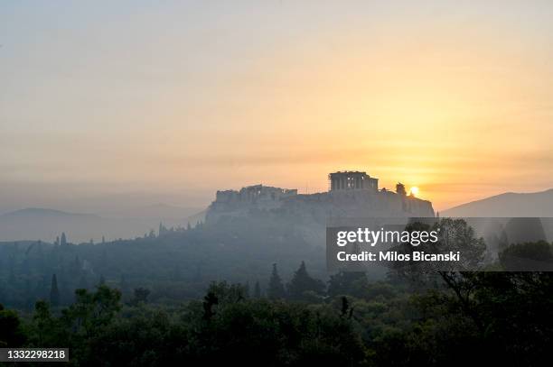 Parthenon temple on Acropolis hill is seen through smoke from a wildfire north of the Greek capital,on August 4, 2021 in Athens, Greece. People were...