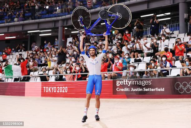 Filippo Ganna of Team Italy lifts his bike to celebrates winning a gold medal after setting a new World record during the Men's team pursuit finals,...