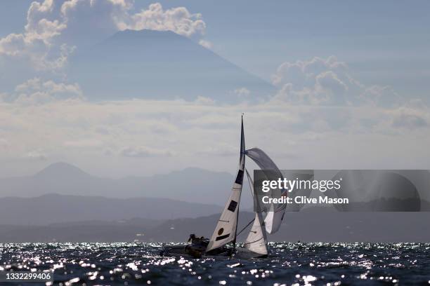 Hannah Mills and Eilidh McIntyre of Team Great Britain compete in the shadow of Mount Fuji on their way to winning the Women's 470 class on day...