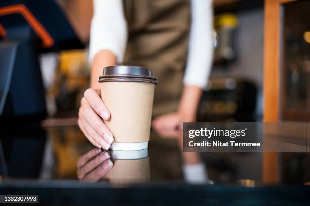 please enjoy drinking a coffee. the unrecognizable waitress serving coffee to a customer in a cafe. serving food and drink, point of sale system. - coffee cup on counter stock pictures, royalty-free photos & images