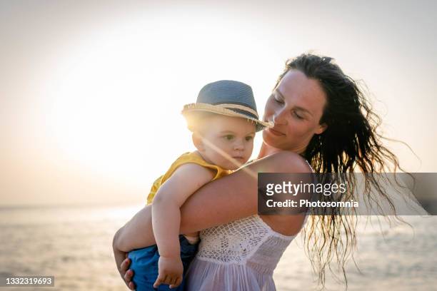 madre y bebé en la playa - mothers day beach fotografías e imágenes de stock
