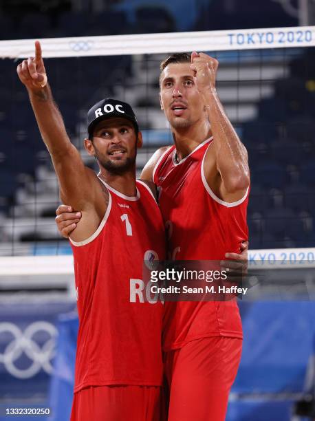 Viacheslav Krasilnikov and Oleg Stoyanovskiy of Team ROC react after defeating Team Germany during the Men's Quarterfinal beach volleyball on day...
