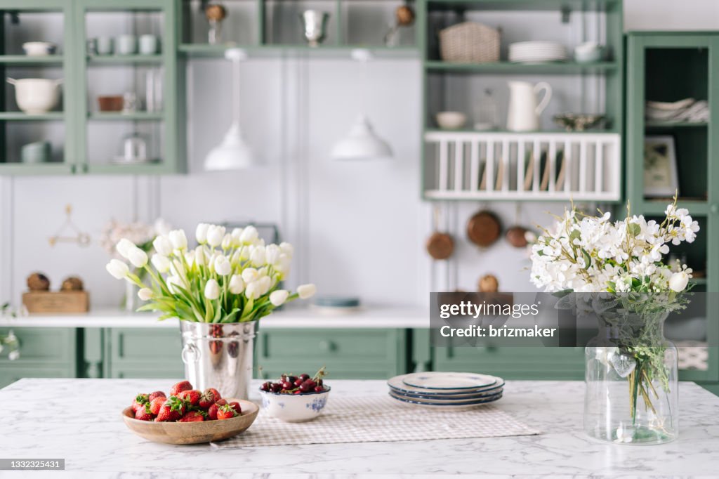 Kitchen countertop with flowers in bucket and jar