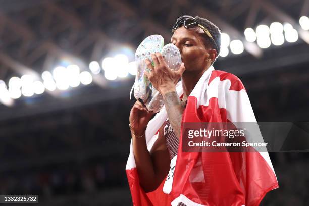 Andre De Grasse of Team Canada kisses his spikes as he celebrates winning the gold medal in the Men's 200m Final on day twelve of the Tokyo 2020...
