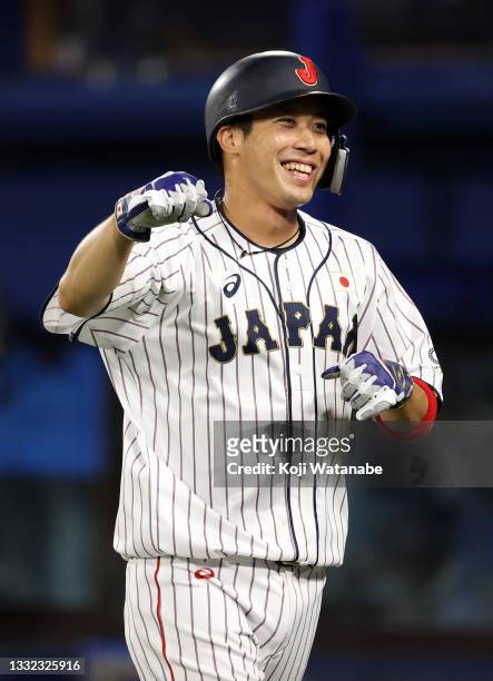 Tetsuto Yamada of Team Japan returns to the dugout after hitting a three-run double in the eighth inning against Team Republic of Korea during the...