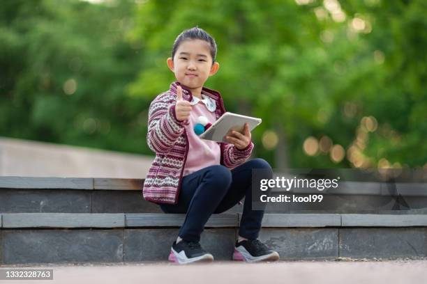 little girl holding ipad - good posture 個照片及圖片檔