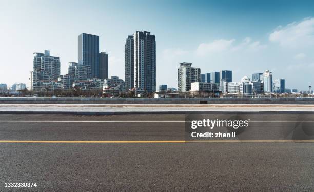 empty urban asphalt road - roadside stock-fotos und bilder