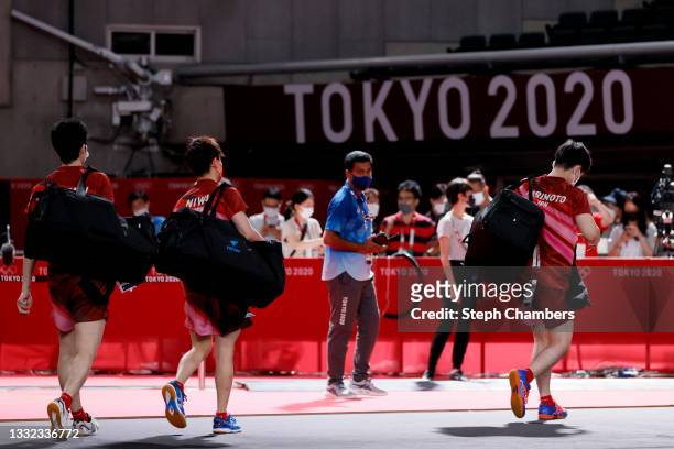Team Japan players Mizutani Jun, Koki Niwa, and Harimoto Tomokazu walk off the court after losing their Men's Team Semifinals table tennis match on...