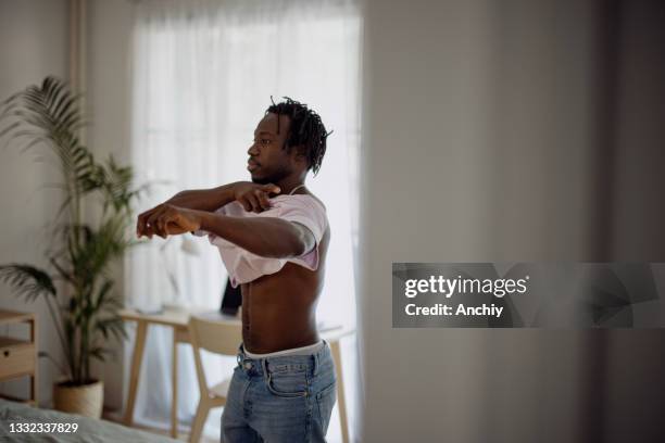 young man getting dressed in his bedroom - getting dressed stock pictures, royalty-free photos & images