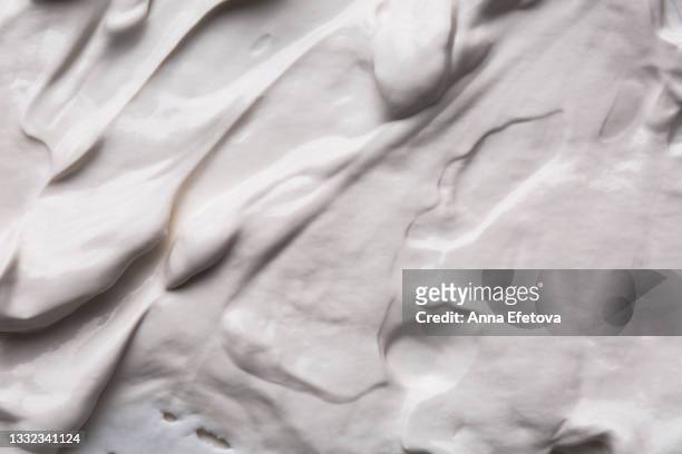 background made of textured smears of white cream. flat lay style - glaçage photos et images de collection