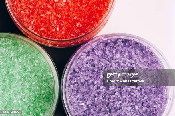 set of three bath salts in open glass jars on white table. concept of body care. flat lay style - bath salt stock-fotos und bilder