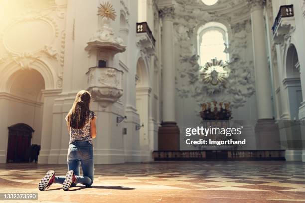 teenage girl praying at church - kneeling stock pictures, royalty-free photos & images