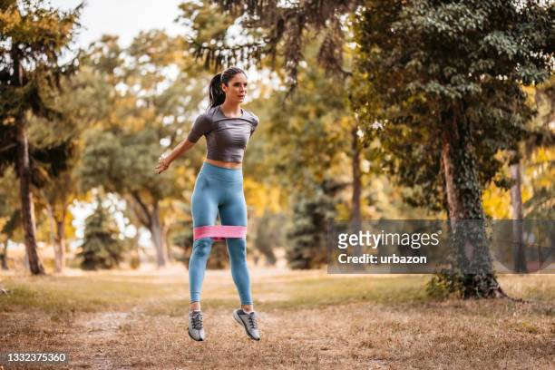 young woman workout in park - squat stock pictures, royalty-free photos & images