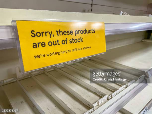 empty supermarket shelves apology sign. covid19 coronavirus pandemic affecting supply lines and deliveries due to lockdowns and closed borders. uk pingdemic causes many essential food and retail staff to self isolate. - assenza foto e immagini stock
