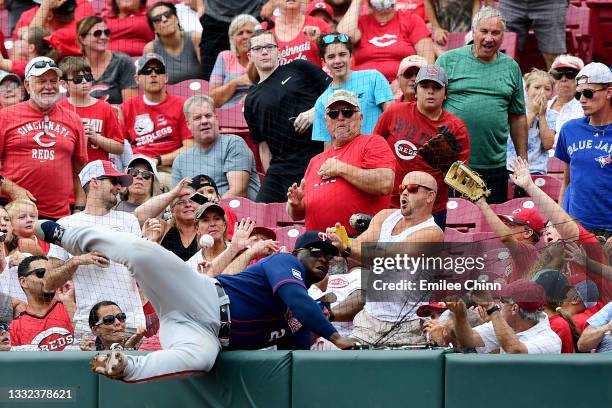 Miguel Sano of the Minnesota Twins falls into the netting while attempting to catch a foul ball hit by Eugenio Suarez of the Cincinnati Reds in the...