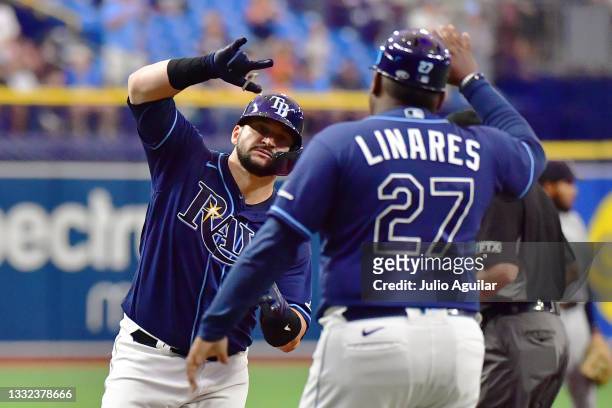 Mike Zunino celebrates with third base coach Rodney Linares of the Tampa Bay Rays after hitting a home run in the sixth inning against the Seattle...