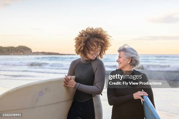 retired happy woman takes surf lessons - woman surfing stock pictures, royalty-free photos & images