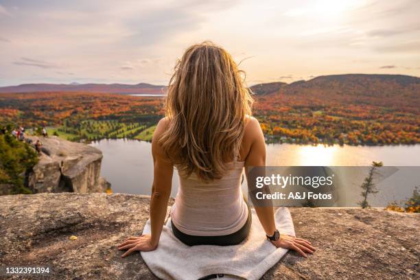 frau, die im herbst auf see und wald schaut. - region new england stock-fotos und bilder