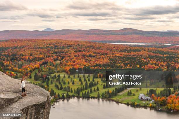 frau, die im herbst auf see und wald schaut. - region new england stock-fotos und bilder