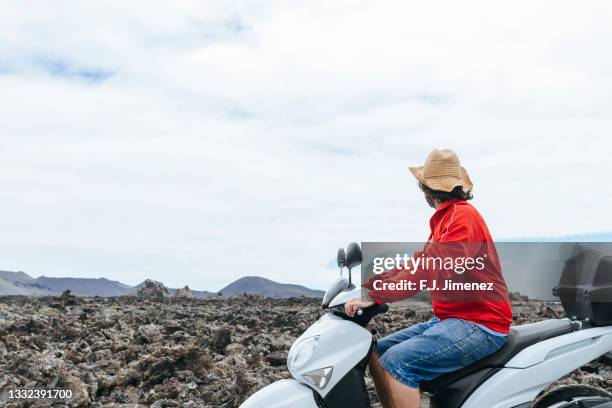 man on motorbike in volcanic landscape of lanzarote - timanfaya stock pictures, royalty-free photos & images