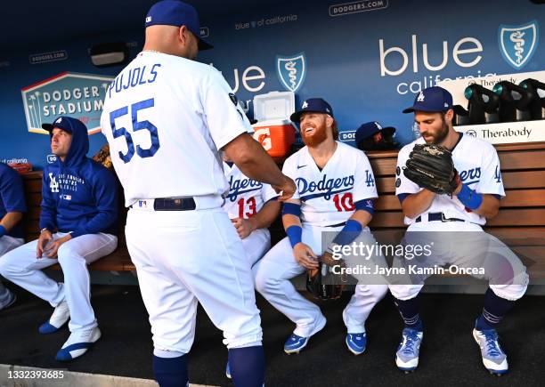 Danny Duffy, Albert Pujols, Justin Turner and Chris Taylor of the Los Angeles Dodgers talks in the dugout before the start of the game against the...