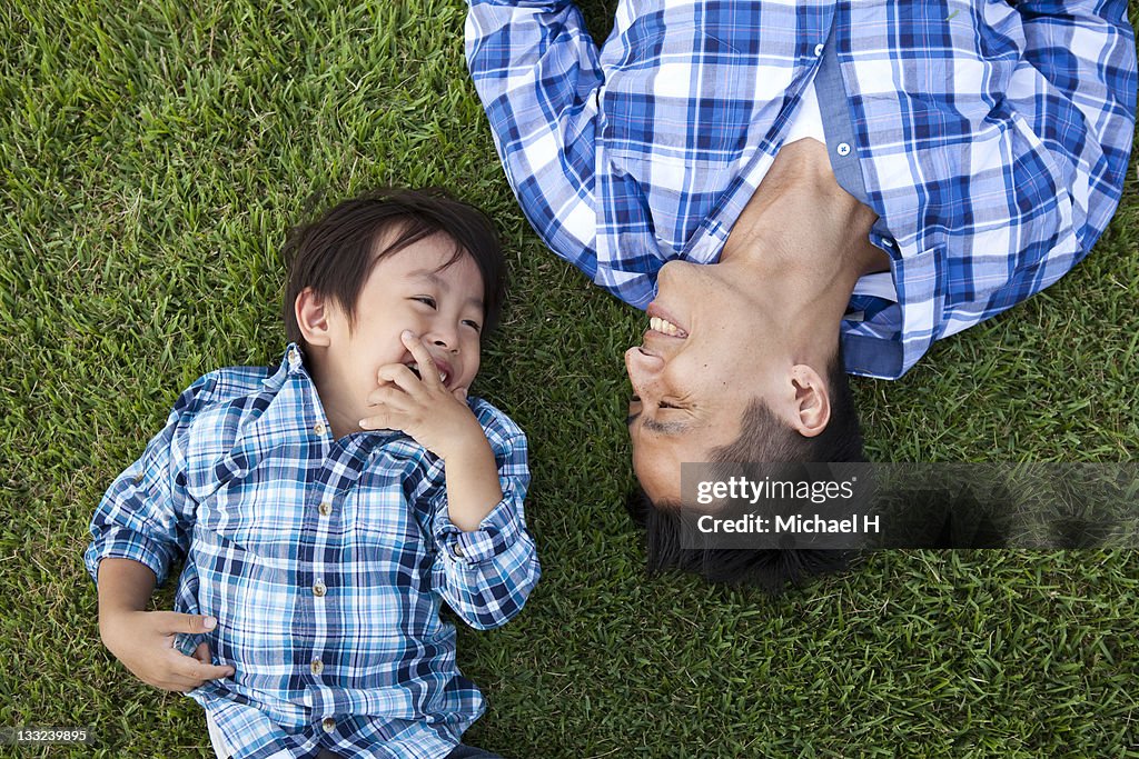 Father and child who have lain down on the lawn