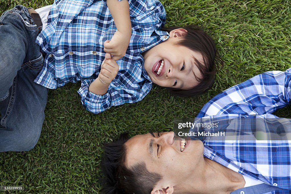 Father and child who have lain down on the lawn