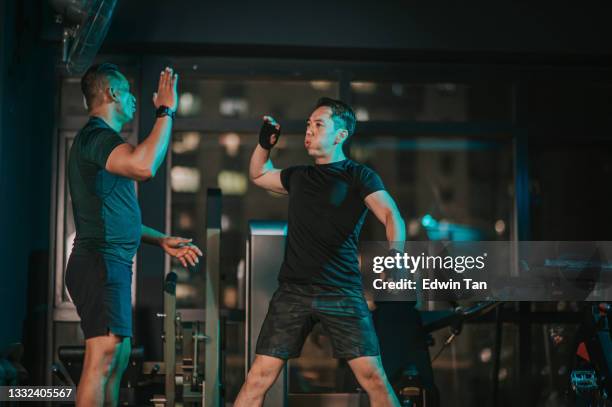 istruttore di fitness indiano asiatico che dà cinque alti al suo studente in palestra dopo l'allenamento - man cheering foto e immagini stock