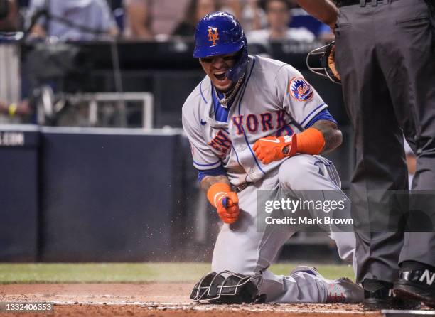 Javier Báez of the New York Mets reacts at home plate after scoring a run in the second inning against the Miami Marlins at loanDepot park on August...