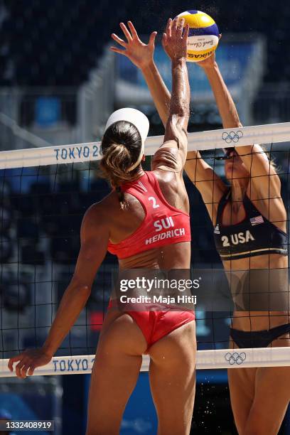 Alix Klineman of Team United States blocks the strike by Joana Heidrich of Team Switzerland during the Women's Semifinal beach volleyball on day...