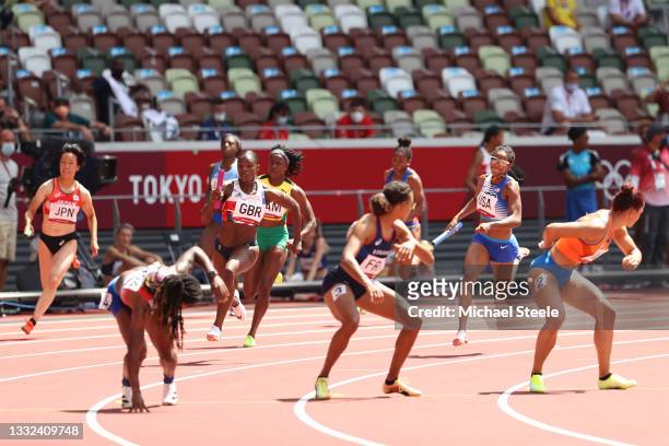 Dina Asher-Smith of Team Great Britain prepares to pass the baton in round one of the Women's 4 x 100m Relay heats on day thirteen of the Tokyo 2020...