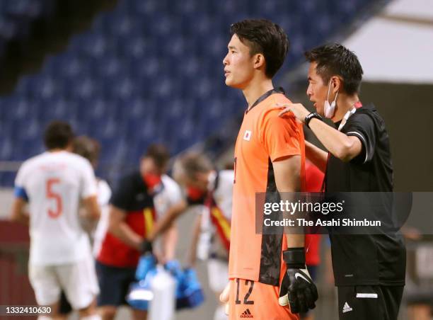 Kosei Tani of Team Japan is advised by goalkeeping coach Yoshikatsu Kawaguchi at the start of extra time during the Men's Football Semi-final match...