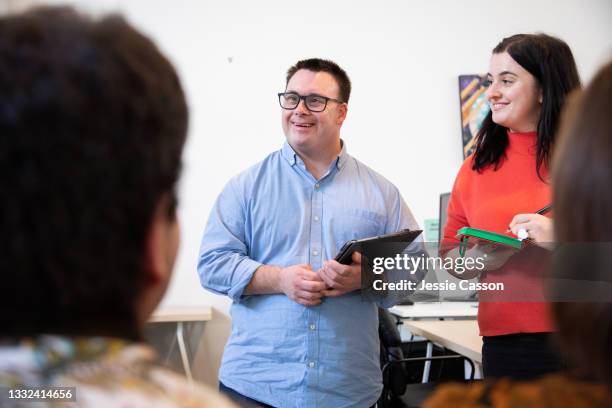 man with down syndrome host a meeting - downsyndrom stock-fotos und bilder